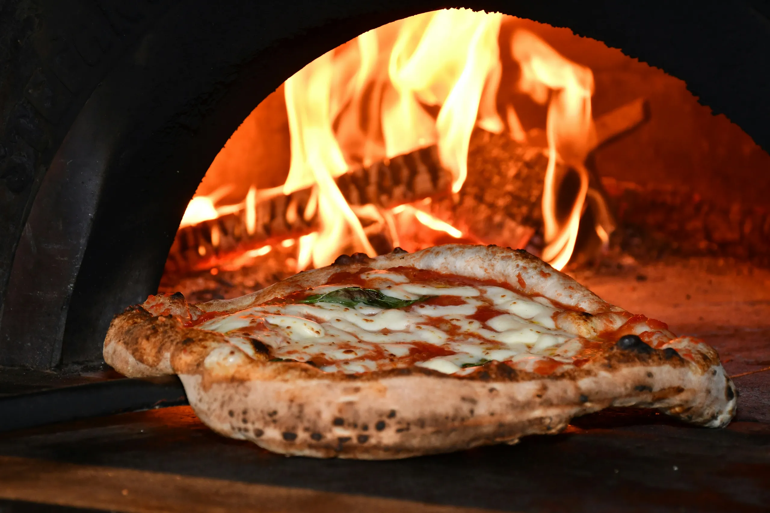 Pizza z przypieczonym brzegiem, mozzarellą, anchois i ziołami